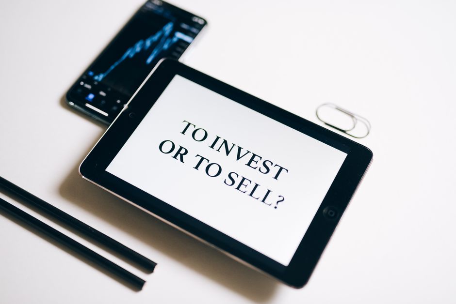 Person holding a tablet with a stock market graph